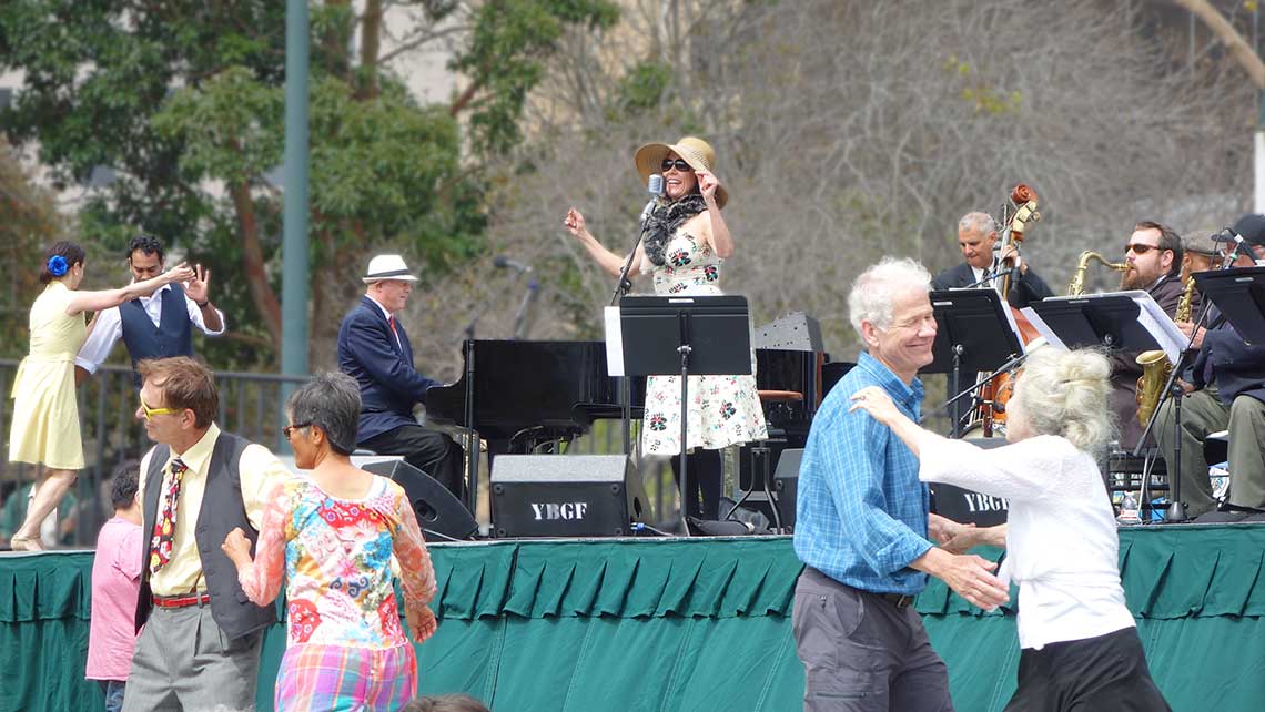 Photo of Lavay Smith and Chris Siebert on stage with swing dancers around