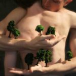 Photo for RAWdance of two people embracing with miniature trees on arms. By Nicholas Terry.
