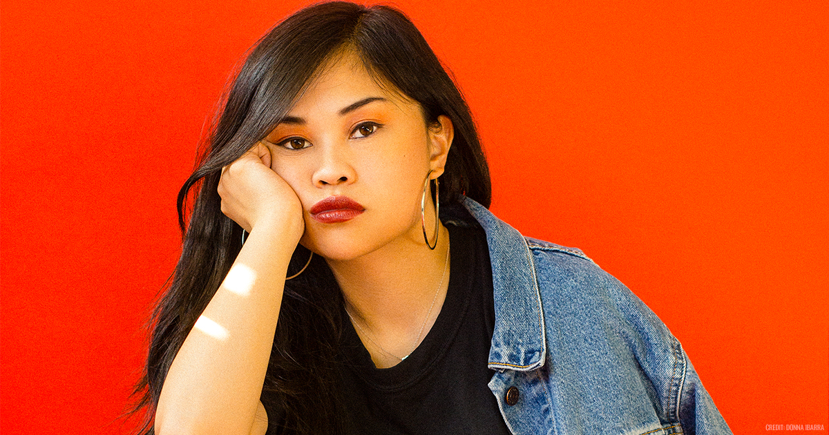 Headshot photo of Ruby Ibarra in front of a bright orange backdrop