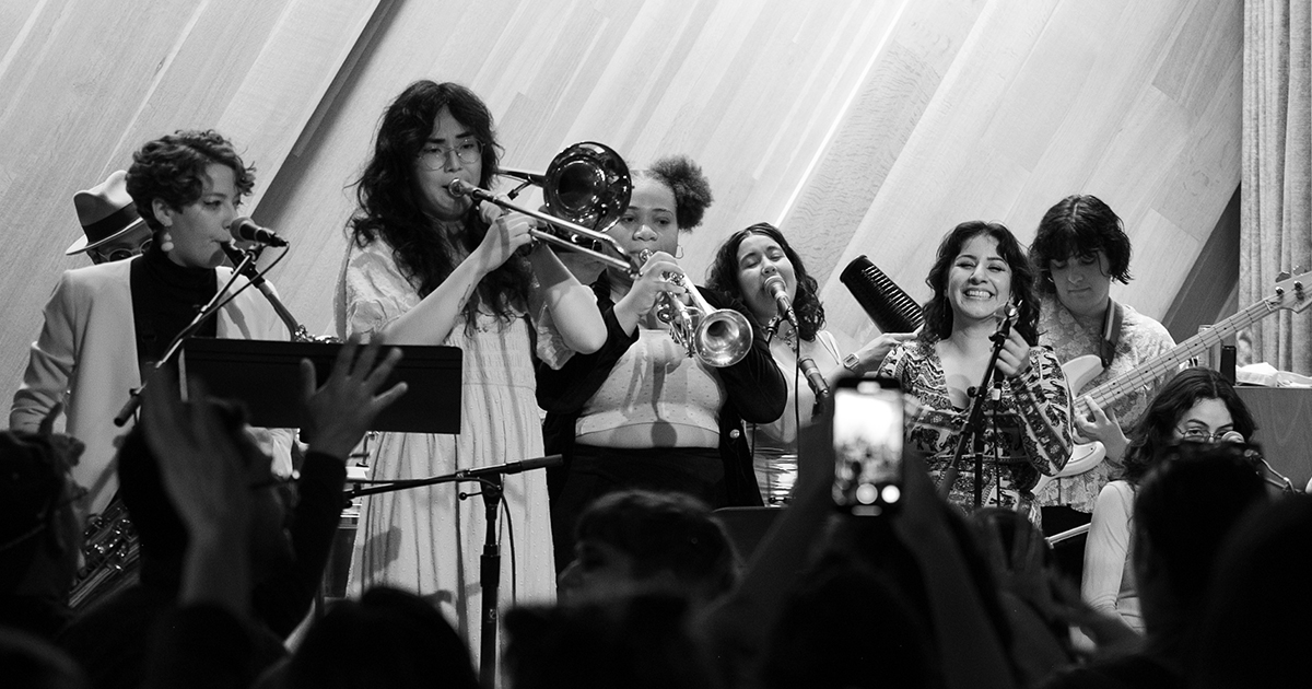 Black and white photos of the members of Agua Pura playing brass instruments and singing on a stage, silhouettes of audiences in front of them