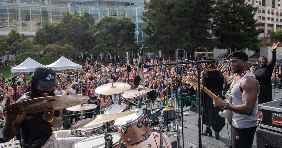 KOKOROKO performing on the YBG Festival stage outdoors in front of a large, vibrant audience