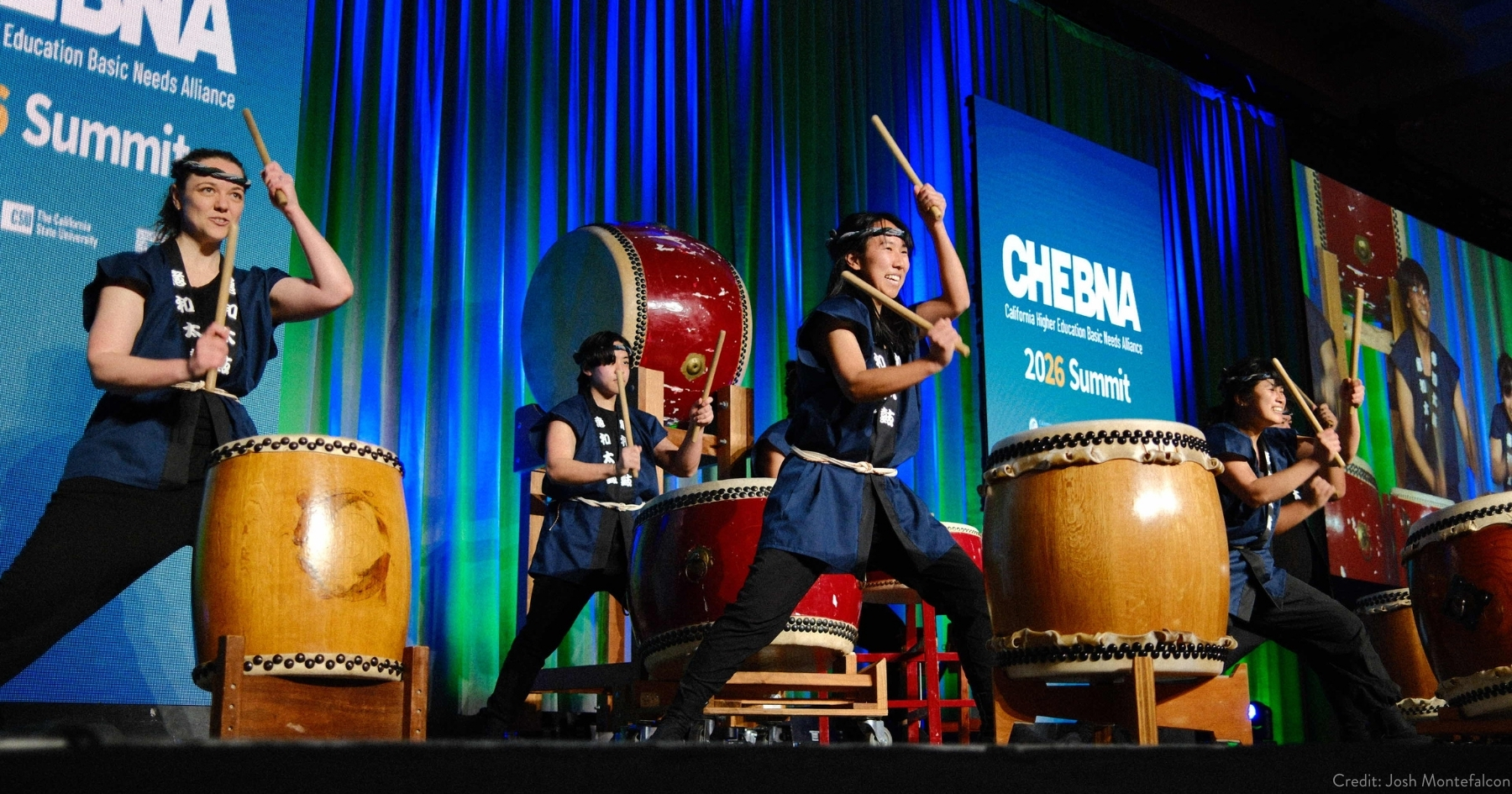 four taiko drummers performing on stage